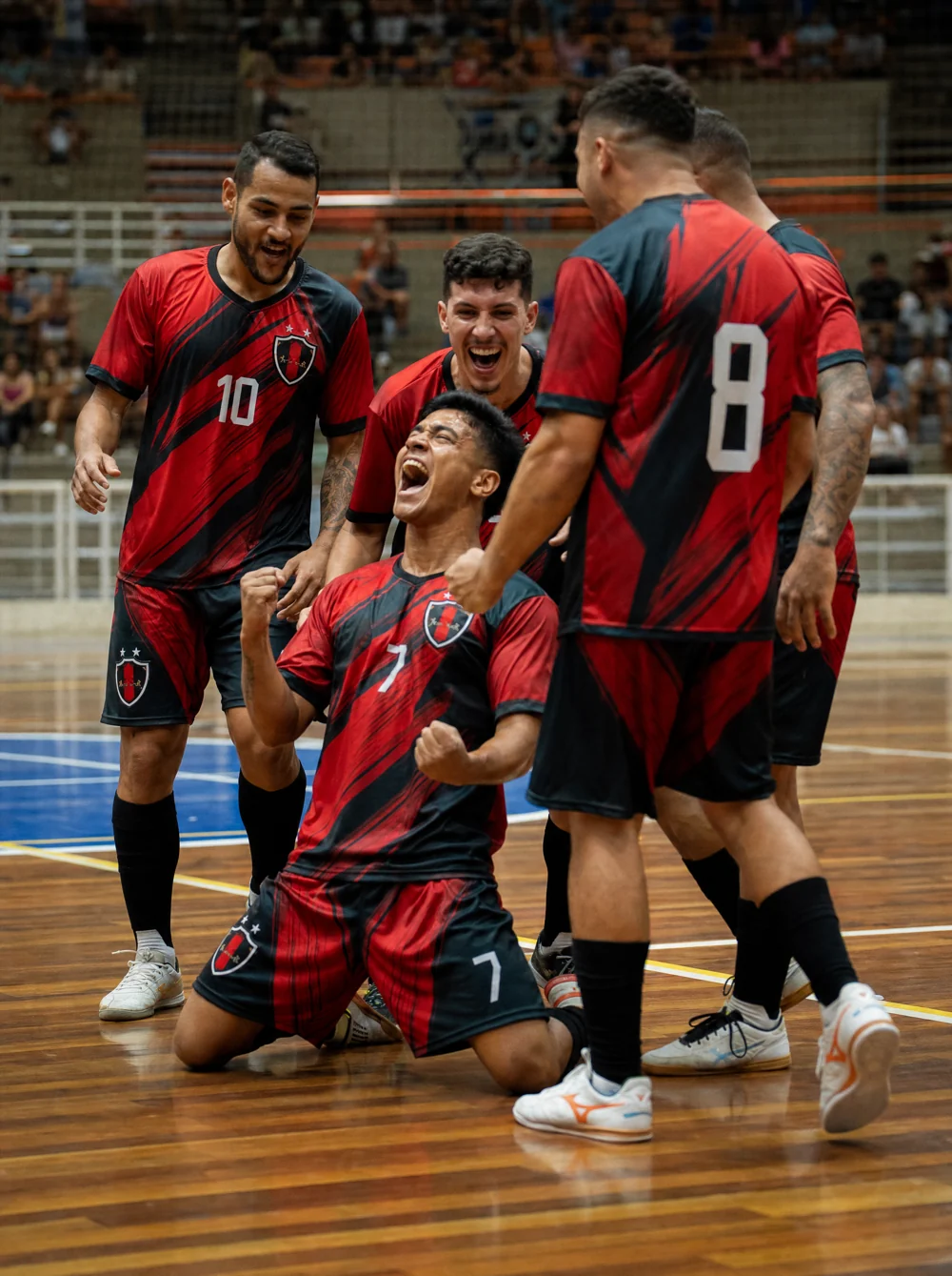 Time de futsal em ginásio indoor com uniforme personalizado vermelho e preto